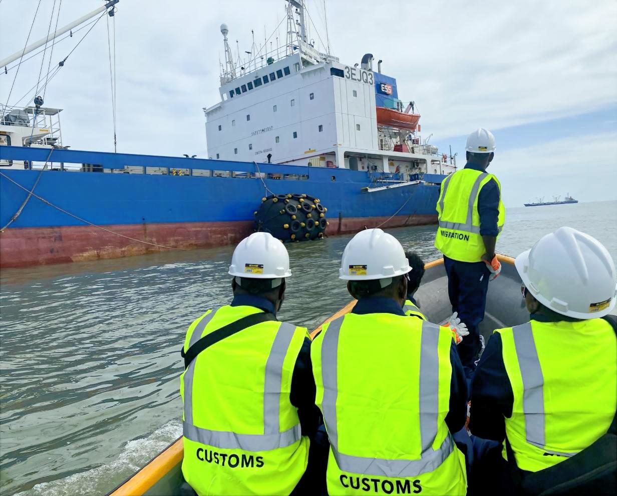 Customs and Immigration officers boarding a cargo vessel for inspection